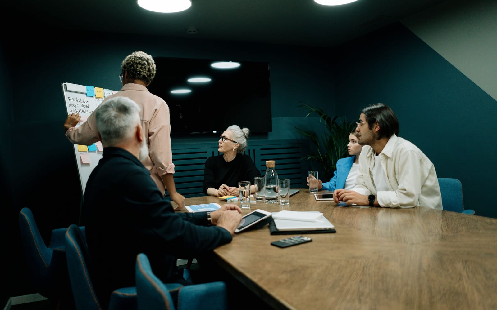 An enterprise meeting in a glass-walled conference room.