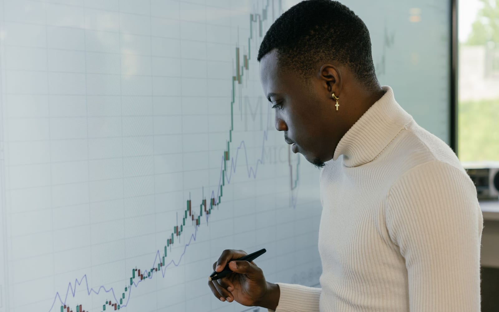 An analyst reviewing figures on a laptop in an office.
